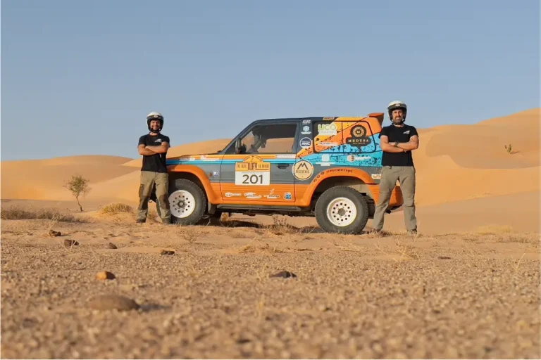 Dois pilotos da equipa Mriderspt posam ao lado do seu veículo todo-o-terreno personalizado com o número 201, em pleno deserto, durante a prova The Real Way to Dakar.